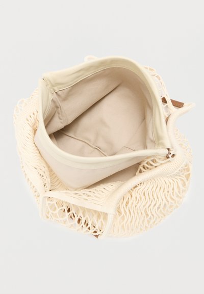 Τσάντα tote από κρεμ δίχτυ με μπεζ εσωτερικό. Διαθέτει κλείσιμο με φερμουάρ και μαλακή επένδυση από ύφασμα. Σχεδιασμός με ανοιχτό άνω μέρος και ανθεκτικές λαβές.