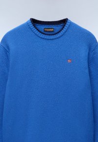 Kungsblå tröja med texturerad yta, rund marinblå krage och liten röd norsk flagga broderad på bröstet. Avslappnad design.