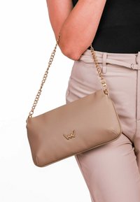Béžová kožená kabelka přes rameno s řetízkem, s jemně embosovaným logem a elegantním obdélníkovým tvarem. Hladká textura, minimalistický design.