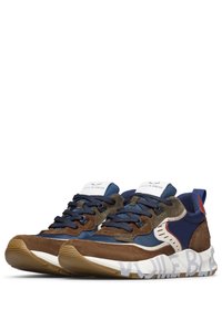 Sneaker ibride con suede marrone e tessuto blu navy, suole in gomma, accenti a contrasto e logo prominente sul lato.