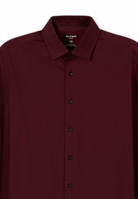 Bordeauxrotes Hemd mit modernem Schnitt, mit spitzem Kragen, sechs schwarzen Knöpfen und einem glatten, strukturierten Stoff. Größe 40.