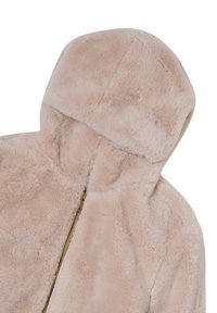 Veste à capuche beige clair douce avec une texture peluche et une fermeture éclair dorée visible partiellement fermée.