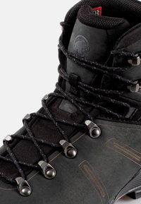 Czarne buty trekkingowe z syntetycznej skóry i tekstylnej cholewki. Wyposażone w metalowe oczka, sznurówki i gumową podeszwę. Zauważalne logo z boku.