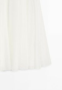 White semi-sheer curtain panels hanging with soft vertical folds against a light background.