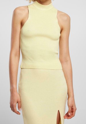 Sleeveless ribbed yellow high-neck top paired with a matching ribbed skirt featuring a front slit.