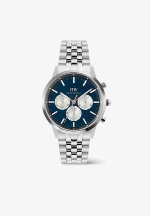 Srebrny zegarek ze stali nierdzewnej z granatową tarczą, trzema subtarczami i srebrnymi znacznikami godzinowymi. Posiada metalową bransoletę i okrągłą kopertę.