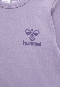 Paarse katoenen sweatshirt met een ronde hals en een bijlogo met daaronder de tekst "hummel". Zachte textuur, casual ontwerp.