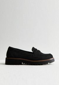 Black suede loafers with a stitched toe, a decorative band across the upper, and a thick, textured rubber sole. Minimalist design.