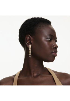 Zlato obarvani uhani z motivom lista, ki imajo bleščeče detajle in dolgo, elegantno obliko. Teksturni površine z jasnimi akcenti.