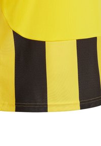 Tessuto giallo con strisce nere. Texture liscia con un design leggero. Presenta un orlo a contrasto. Materiale in poliestere.