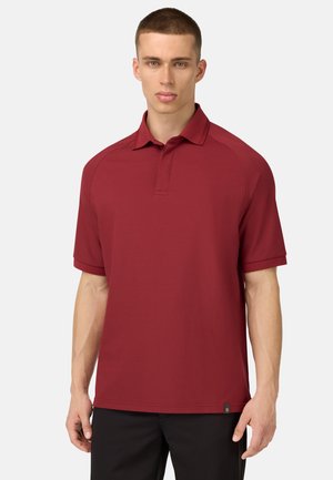 Bordeauxfarbenes Polohemd mit kurzen Ärmeln, Kragen und genähten Details. Besitzt ein kleines schwarzes Etikett am Saum.
