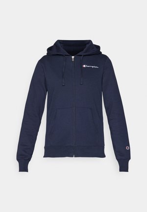 Tamsiai mėlynas užtrauktuko megztinis pagamintas iš minkštos medžiagos, su kengūros kišene, su raišteliu reguliuojama kapuce ir siuvinėjamu logotipu ant krūtinės.