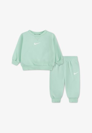 Ensemble sweat-shirt et pantalon de jogging pour tout-petit Nike vert menthe avec poignets côtelés et logos blancs sur la poitrine et la jambe du pantalon.