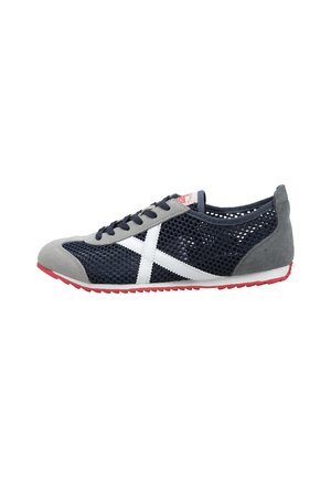 Baskets en mesh bleu marine avec bout et talon en daim gris, détail blanc en forme de croix sur le côté, lacets noirs et semelle en caoutchouc rouge.