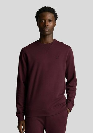 Felpa bordeaux in tessuto misto cotone, con scollo rotondo, polsini a costine e un delicato dettaglio logo sul petto.