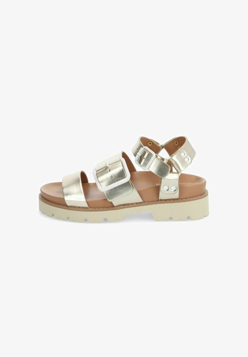 Sandales métalliques dorées avec deux larges lanières, détails de boucle et une semelle blanche épaisse. Texture lisse avec un design plat.
