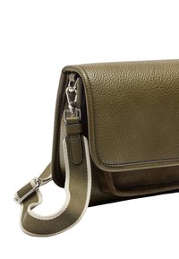 Zielono-oliwkowa skórzana torebka na ramię o fakturowanej powierzchni, zamykana na klapkę, z odpinanym paskiem na ramię z plecionym akcentem.