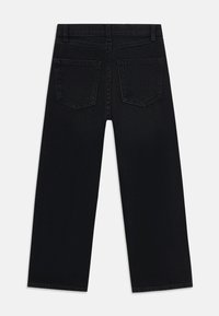 Black denim jeans with a straight leg fit, featuring two back pockets and a classic waistband design. Smooth texture and uniform color.