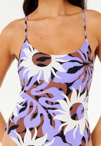 Maillot de bain multicolore avec un motif floral en blanc, violet et marron. Il a des bretelles fines et une coupe ajustée. Texture de tissu douce.
