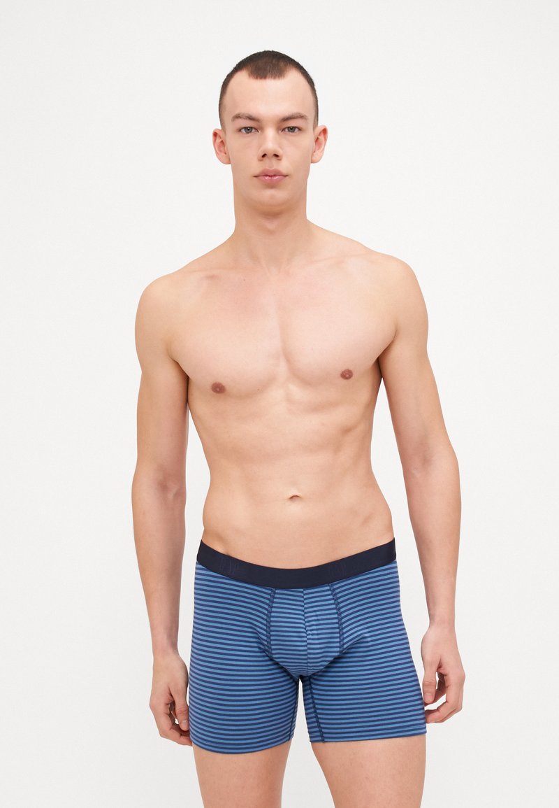 Boxer-briefs bleus pour homme avec rayures horizontales, tissu doux, taille élastique et détails cousus, offrant une coupe ajustée.