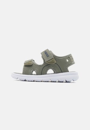 Green synthetic sandals with white soles, featuring adjustable Velcro straps and cut-out details for ventilation. Flat sole and textured insole.