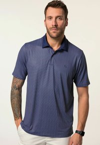 Námořnické polo tričko s texturovaným mřížkovým vzorem, krátkými rukávy a tmavým límcem. Obsahuje logo na hrudi a boční rozparky pro pohodlí.