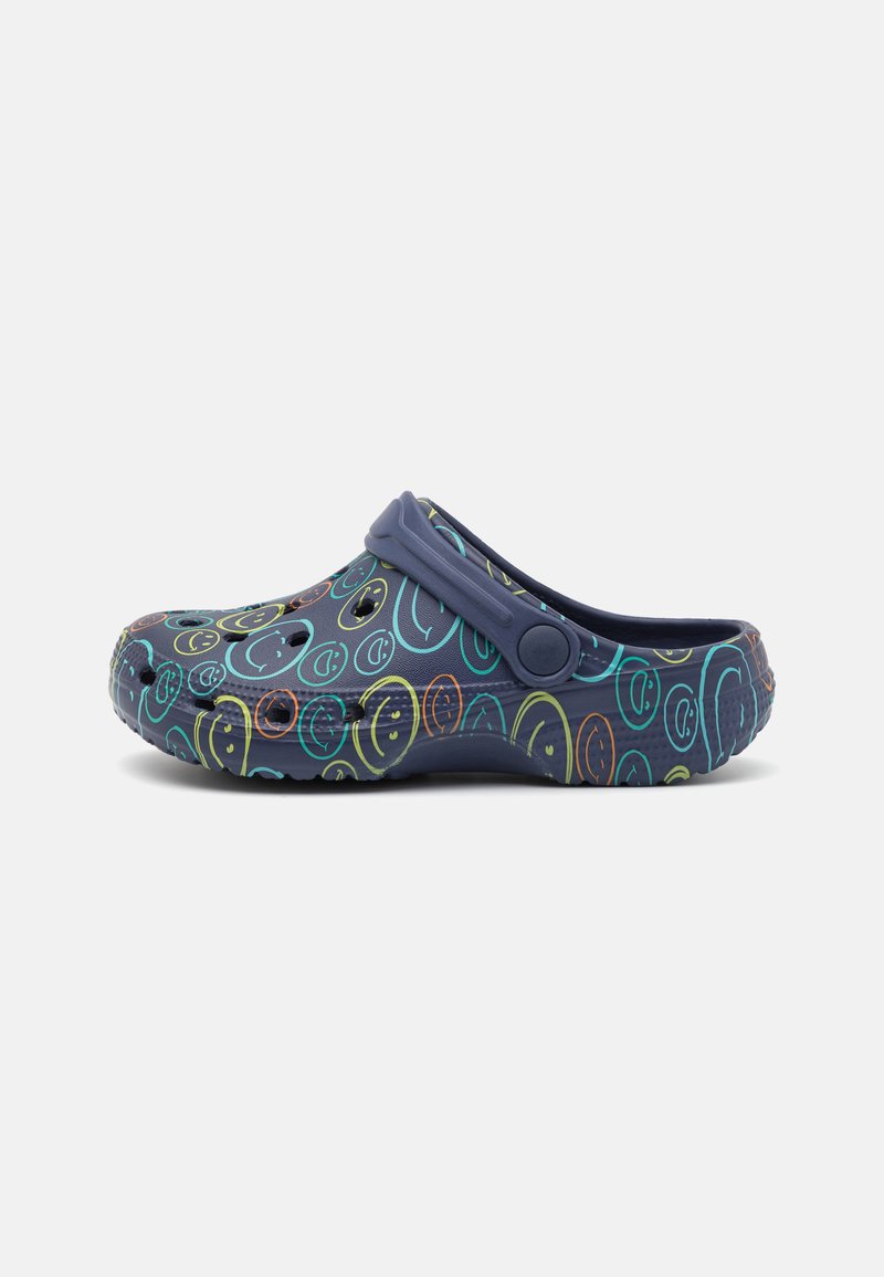 Patterned clogs with a navy base, featuring multicolored smiley face designs. Made of lightweight material with ventilation holes and a strap.