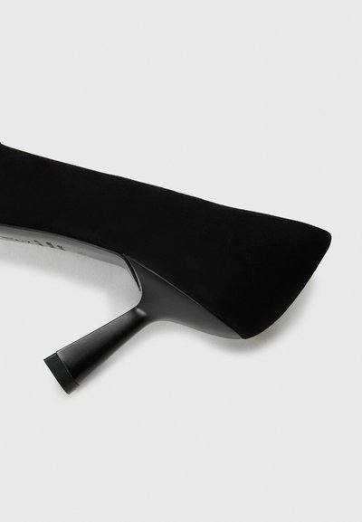 Black suede high heel shoe with a pointed toe and a slender, tapered heel. The shoe features a smooth texture and minimal detailing.