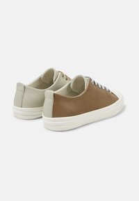Brown and light gray leather sneakers with white rubber soles, featuring round toe, flat laces, and minimalistic design.
