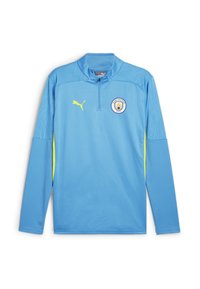 Lichtblauwe sporttop met lange mouwen, voorzien van een halve rits, gele accenten, textuurstof en het Manchester City-logo op de borst.