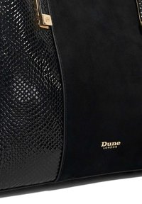 Zwarte handtas van gestructureerde faux slangenhuid en gladde suede, met gouden hardware en geprinte branding aan de voorkant.