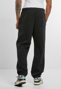 Upscale by Mister Tee Teplákové kalhoty - black