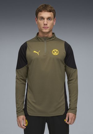 Oliven grøn atletisk pullover med høj krave, lynlås lukning, sorte sidelapper og gule logoer på brystet og armen. Tekstureret stof.