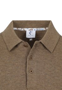 Bruine gebreide polo met kraag, voorzien van twee knopen en een gemarmerd binnenlabel bij de hals. Textuurstof met een subtiel streepjespatroon.