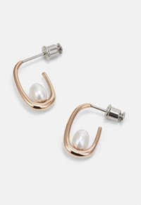 Roséguld metal örhängen med en böjd design, med en vit pärla i varje. Inkluderar en silverstift och baksida.