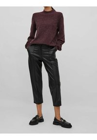 Vínový pletený svetr s kulatým výstřihem, ve spojení s černými zkrácenými kalhotami z umělé kůže a černými mokasínami se zlatým akcentem.