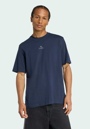 Mørkeblå bomulds t-shirt med korte ærmer, rund hals og logo-print på forsiden. Båret med sorte denimshorts, der har en lige pasform.
