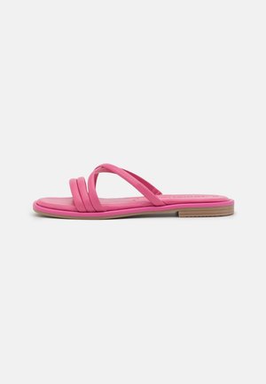 Flad lyserød sandal med tre tynde frontstropper og en lav beige sål på en hvid baggrund.