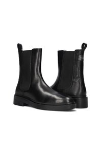Pair of black leather Chelsea boots with elastic side panels and textured heel detail, positioned against a white background.