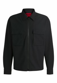 Zwarte zip-up jas met een puntige kraag, twee voorste klepzakken, gestructureerde stof en subtiele "HUGO" branding op de zak.