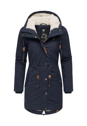 Granatowa parka z kapturem wyłożonym sztucznym futrem, ściągaczami, drewnianymi detalami i zatrzaskami. Posiada boczne kieszenie oraz lekko zaokrąglony dół.