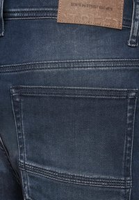 Tmavě modré džíny z denimu s hladkou strukturou, s vyztuženým šitím a koženou nášivkou na pasu s nápisem "DENIM by STREET ONE MEN."