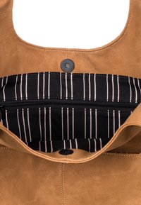 Kabelka z hnědé koženky se zapínáním na magnet. Podšívka je vyrobena z černé látky s růžovými vertikálními pruhy a obsahuje kapsu na zip.