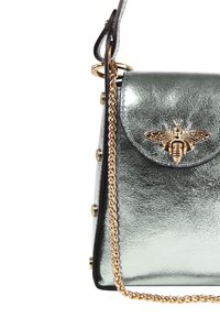 Metallic groene handtas met een klepsluiting, gouden bijenembleem, kettinghengsel en gouden hardware-accenten. Gevoelde afwerking voegt details toe.