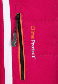 Giacca fucsia con zip nera e dettaglio arancione, con logo "Clima Protect" ricamato in bianco. Tessuto liscio e resistente.