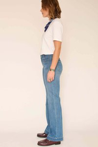 Jean évasé bleu clair à taille haute, en denim. Comprend un design classique à cinq poches et un léger délavé de couleur.