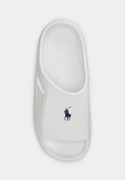 Λευκό σανδάλι slip-on με ανοιχτά δάχτυλα και πλαϊνά ανοίγματα, με μικρό μαύρο λογότυπο παίκτη πόλο στο πάνω λουράκι.