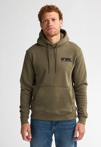 Felpa verde oliva con tasca a marsupio frontale, cappuccio con lacci e logo nero sul petto. Tessuto morbido con polsini e orlo a costine.