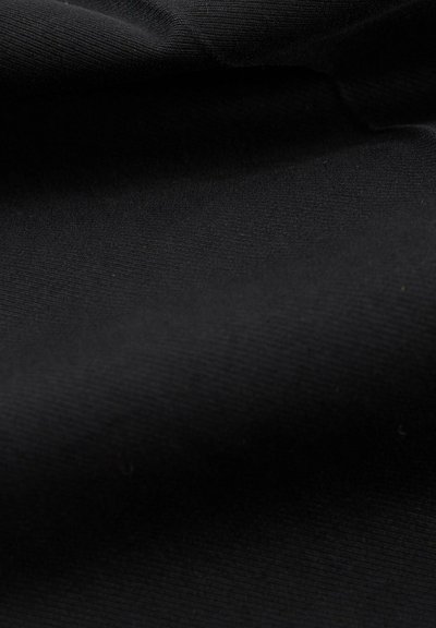 Tessuto nero con una superficie liscia, caratterizzato da un sottile motivo a coste e una leggera lucentezza, drappeggiato per mettere in evidenza la sua flessibilità e il suo profilo.