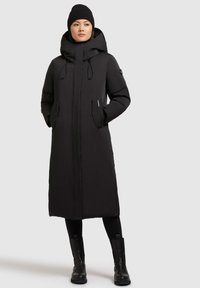 Černý zateplený dlouhý kabát s kapucí, předním zipem, stahovacími šňůrkami a bočními kapsami. Hladká textura, rovný střih a minimalistický design.